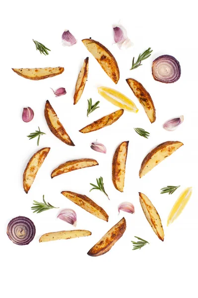 Scheiben von Ofenkartoffeln, Rosmarin, Knoblauch und Zitrone auf einem weißen Ba Stockbild