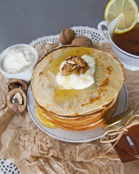 Frittelle con panna acida e miele, decorate con noce — Foto Stock