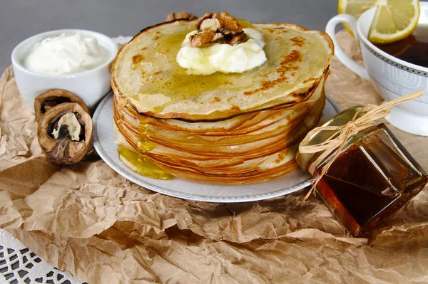 Frittelle con miele e panna acida e noci su un tovagliolo di carta — Foto Stock