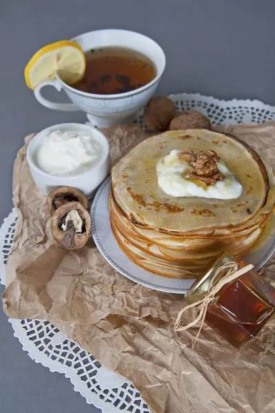 Frittelle con panna acida e miele, decorate con noce — Foto Stock