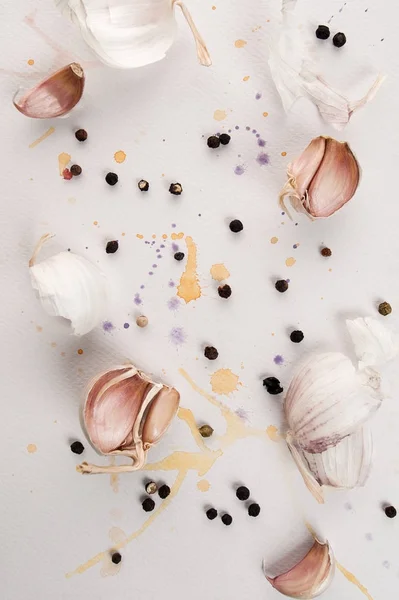 Dientes de ajo y pimienta picante negro se encuentran en un bac de textura blanca — Foto de Stock