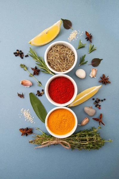 Curry, rozmaryn, papryka i pikantne zioła na jasny niebieski pastel — Zdjęcie stockowe