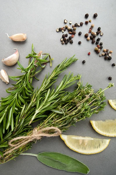 Fresh spicy herbs and a mixture of peppers on a gray stone table — Stock Photo, Image