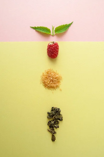 Maliny, cukr, list máty a hrst zeleného čaje na — Stock fotografie