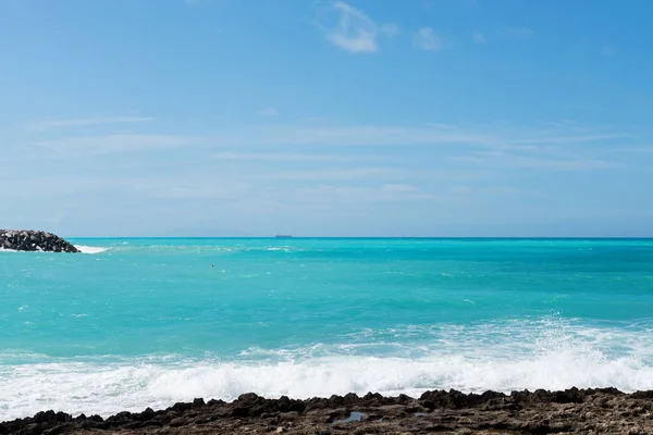 Mar azul bonito e a praia rochosa — Fotografia de Stock
