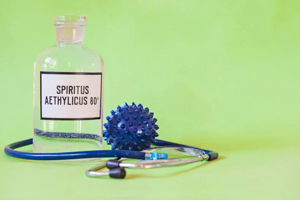 Ethanol in a bottle on the table with of microscope virus close up and stethoscope, Coronavirus concept Tablet in the fingers of hand — Stock Photo, Image