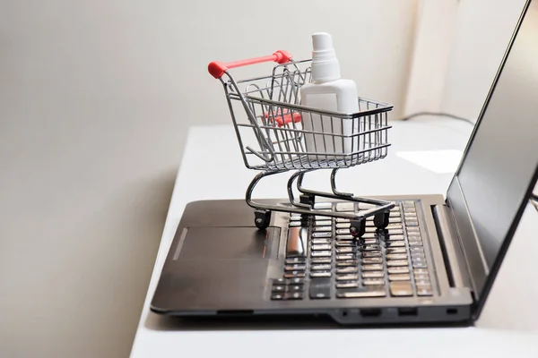 Conceptual photo with miniature shopping-cart and antiseptic. Safety internet shopping — Stock Photo, Image