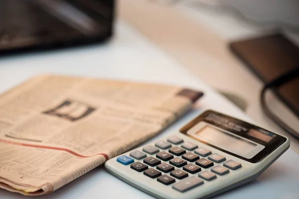 Taschenrechner und Finanzzeitung. Coronavirus-Konzept. Arbeit von zu Hause aus — Stockfoto