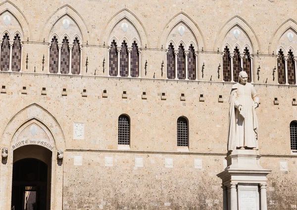 銀行モンテ ・ デイ ・ Paschi ・ ディ ・ シエナ パラッツォ Salimbeni とサッルスティウス バンディーニの記念碑の建物です。シエナ、イタリア. — ストック写真