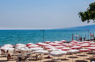 Balçık deniz, kum, güneş şemsiyesi ile plaj