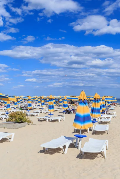 Černomořské pobřeží, Modrá čistá voda, pláž s pískem, slunečník a lehátka. Albena, Bulharsko — Stock fotografie