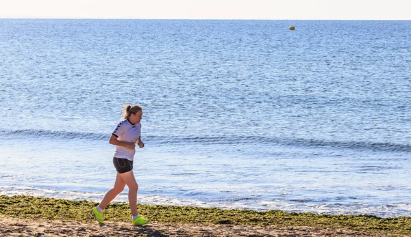 Chica corre a lo largo de la costa — Foto de Stock