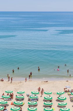Karadeniz kıyı, mavi berrak su, kum, plaj şemsiye. Albena, Bulgaristan