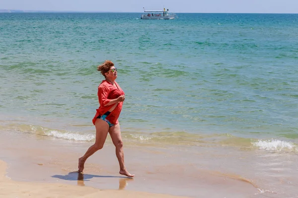 Mulher corre ao longo da costa — Fotografia de Stock