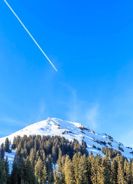 Avion dans un ciel bleu avec des traces. Mountain Hohe Salve en hiver — Photo