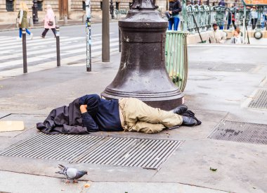 Louvre yakınındaki street üzerinde sağa evsiz clochard uyuyor. Paris, Fransa