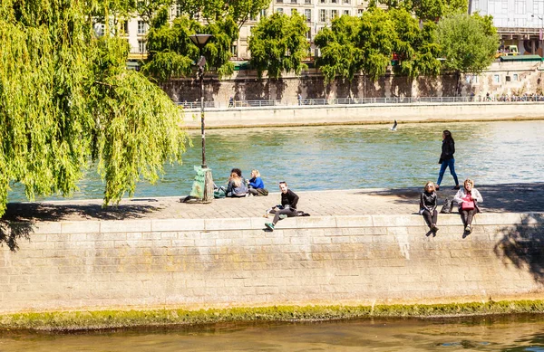 Остров Города. Люди сидят на набережной Орфевра. Париж — стоковое фото