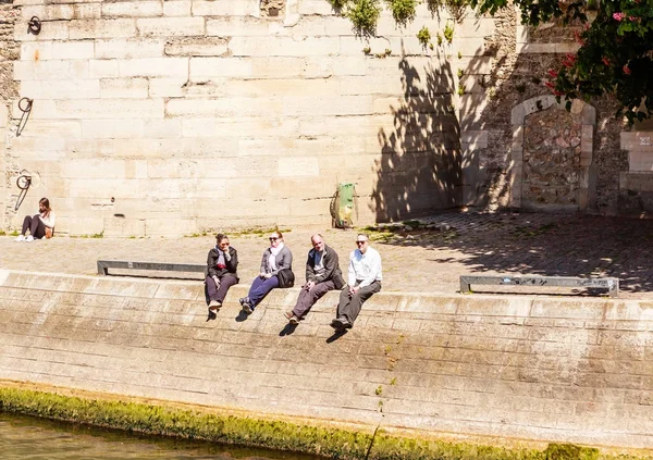 Isla de la Ciudad. La gente se sienta en el Quai des Orfevres. París, Francia — Foto de Stock