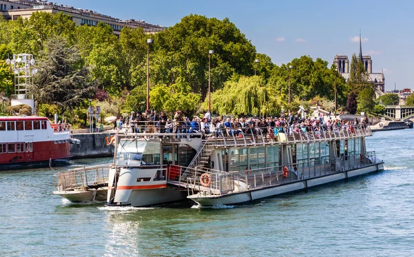 Una vista panorámica del río Sena con un barco turístico y turistas en cubierta. Francia, París —  Fotos de Stock