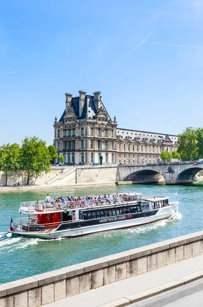 Туристическая лодка с туристами возле Лувра — стоковое фото