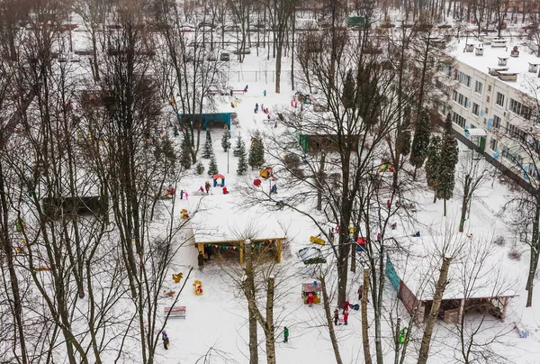Los niños en el parque infantil en el jardín de infantes en el invierno —  Fotos de Stock