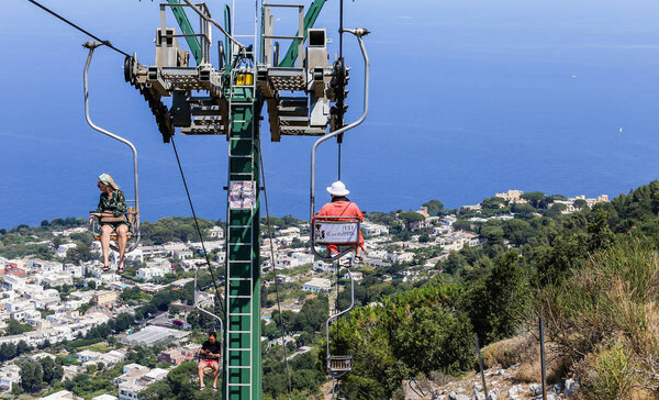  Туристы катаются вверх и вниз по горному подъемнику
. 