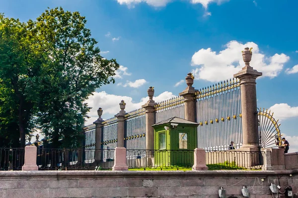 Clôture élégante en fer forgé ornée de vases et de détails dorés — Photo