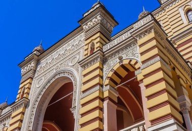  Tiflis Opera ve bale salonunun girişinin üstündeki kemer, mavi gökyüzüne karşı çiçeklerle süslenmiş.