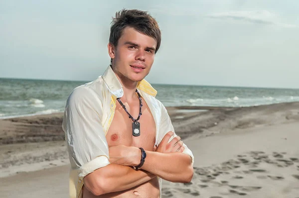 Knappe man op strand glimlachen tijdens vakantie in vakantiepark. — Stockfoto