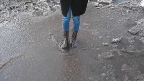 Pessoas em botas em uma poça no inverno — Vídeo de Stock