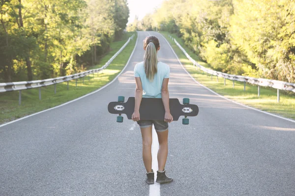 Mädchen mit Longboard. lizenzfreie Stockbilder