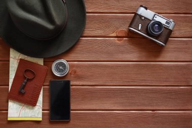 Koyu ahşap arka plan üzerinde seyahat aksesuarları.