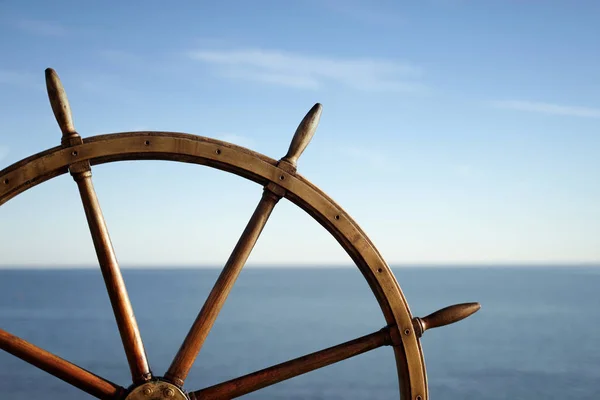 Ship wheel and blue sea on background. — ストック写真
