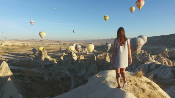 Mujer Caminando Borde Del Rock Mirando Globos Aerostáticos Capadocia Turquía — Vídeo de stock