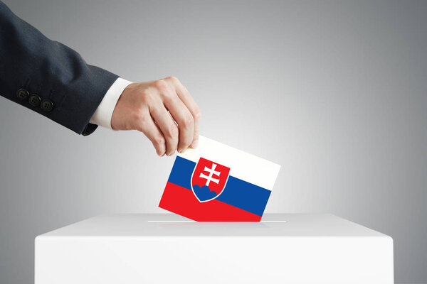 Man putting a ballot into a voting box.