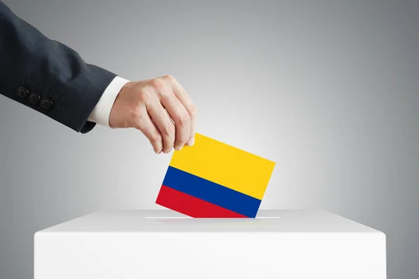 Hombre Poniendo Una Papeleta Votación Una Caja Con Bandera Colombiana —  Fotos de Stock