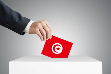 Tunus bayrağı taşıyan bir sandığa oy veren adam.