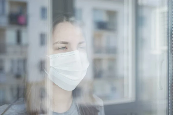 Jonge Vrouw Quarantaine Kijkend Uit Het Raam Stockfoto