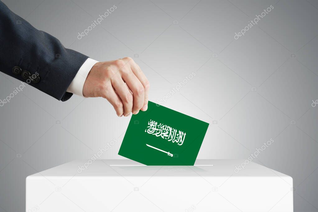 Man putting a voting ballot into a box with Saudi Arabia flag.