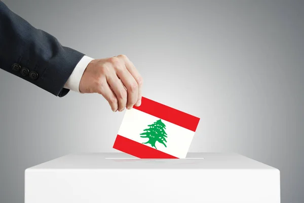 男子将选票放入装有黎巴嫩国旗的盒子 — 图库照片