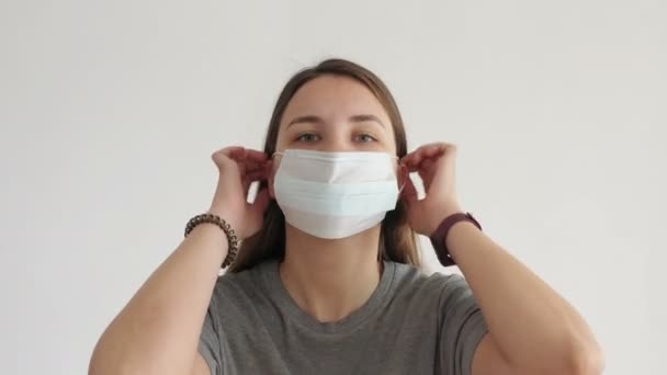 Kvinna Sätter Ansiktsmask Vit Bakgrund Coronavirus Covid — Stockvideo
