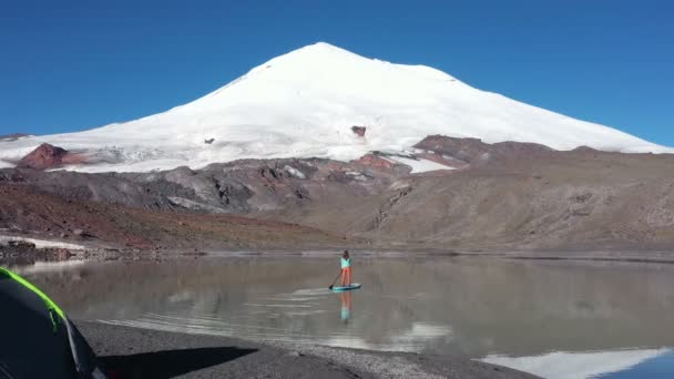 在海拔3300米处的山地湖上 站起来的垫板上有一个女人的脚步声 俄罗斯Elbrus山 — 图库视频影像