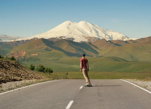 Man Riding Skateboard Road Elbrus Najwyższa Góra Europie — Zdjęcie stockowe