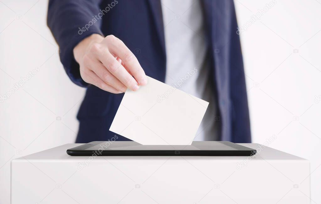 Businessman Putting a Ballot into a Digital Tablet. Voting Online Concept.