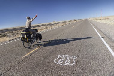 ABD 'nin New Mexico şehrinde 66. tarihi yolda bisiklete binen adam. Yol Yazdırmaya Odaklan.