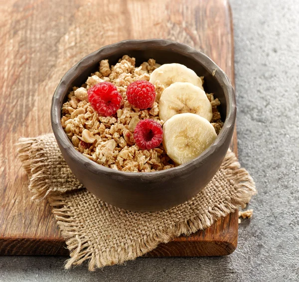 Bowl of granola with banana and raspberries — Stock Photo, Image