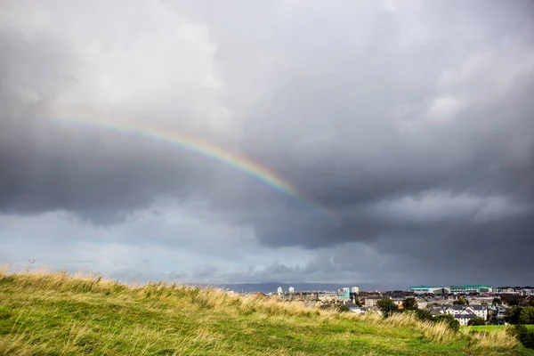 Cielo nublado y arco iris sobre la ciudad — Foto de Stock