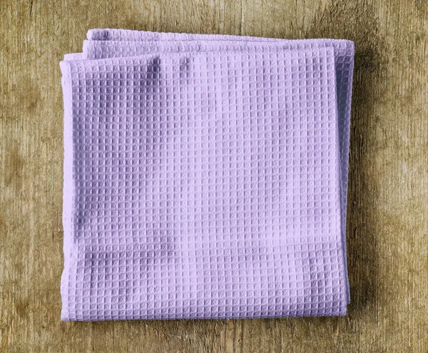 Violet towel on wooden table — Stock Photo, Image