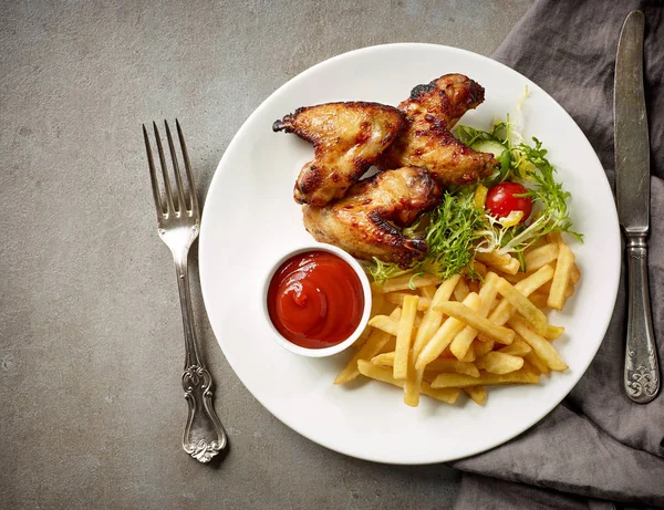 Placa de papas fritas y alitas de pollo — Foto de Stock