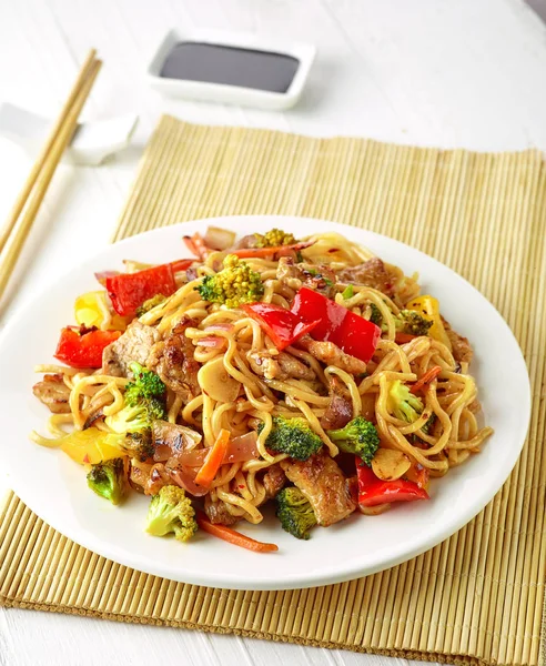 Plate of noodles with meat and vegetables — Stock Photo, Image